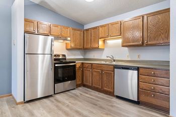 A kitchen with wooden cabinets and stainless steel appliances.