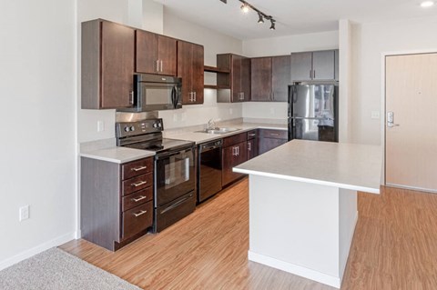 a large kitchen with wooden floors and stainless steel appliances
