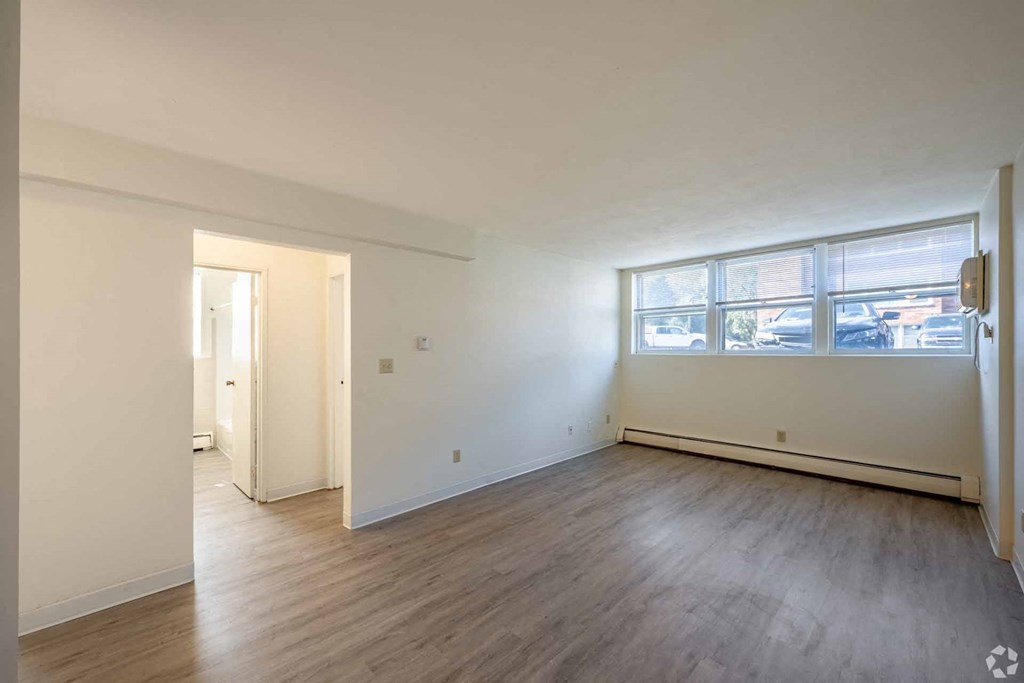 A room with wooden flooring and a large window.
