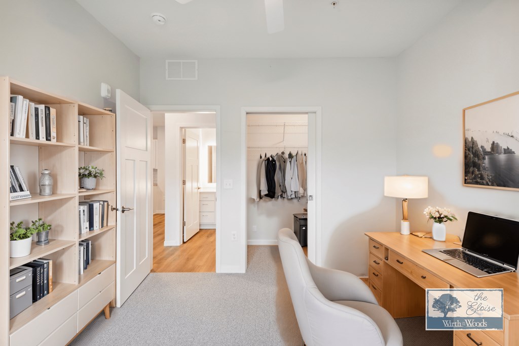 a bedroom with a desk and a chair and a closet