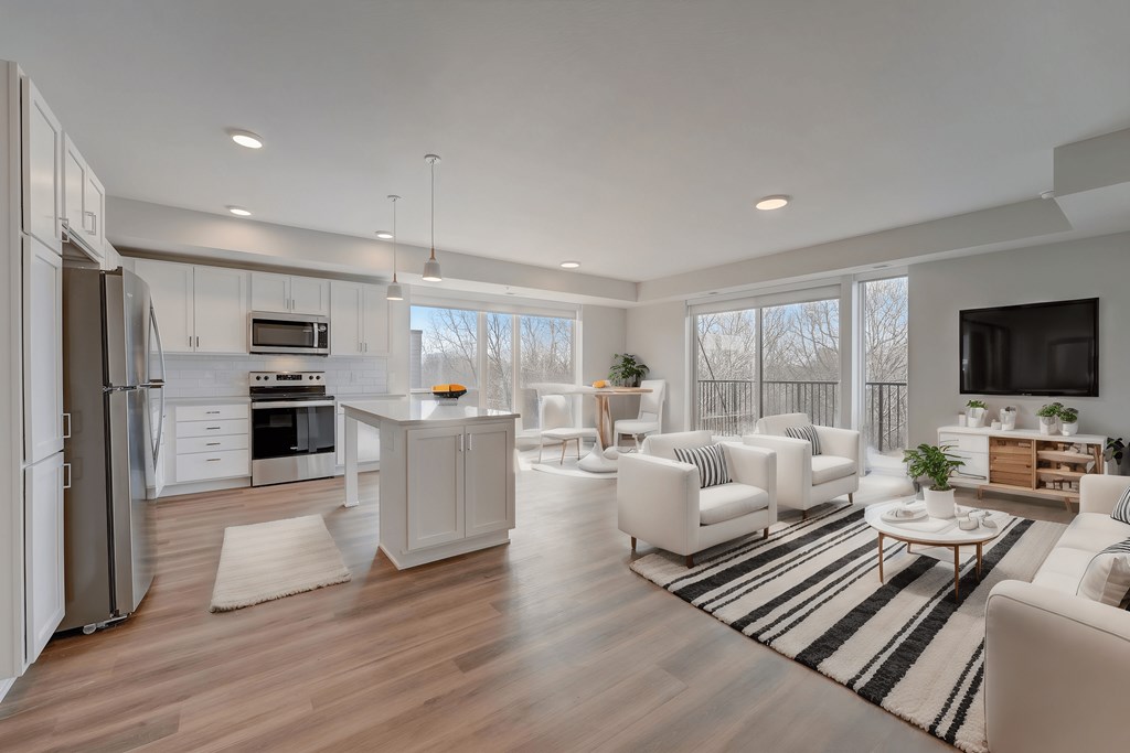 a white living room with a kitchen and a rug