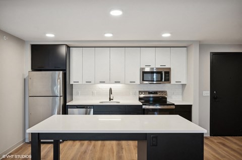 a kitchen with white cabinets and stainless steel appliances
