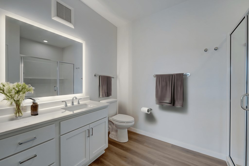 a white bathroom with a large mirror and a toilet