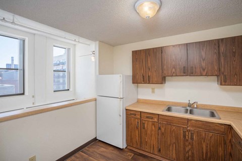 a kitchen with wooden cabinets and a sink and a refrigerator
