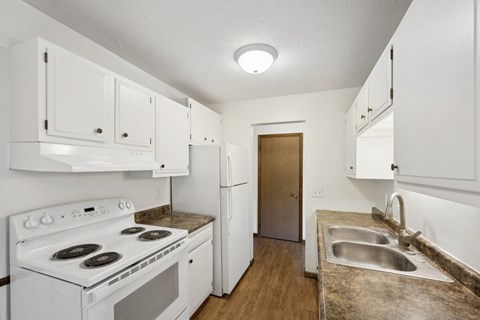 a kitchen with white appliances and white cabinets