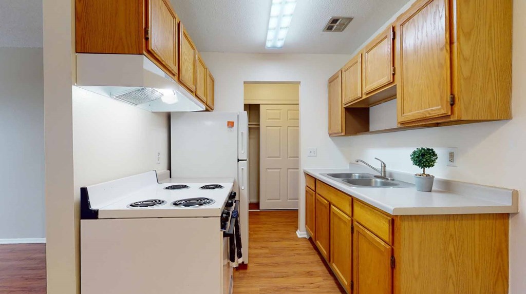 A kitchen with wooden cabinets and a white countertop.
