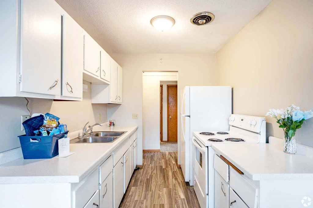 A kitchen with white appliances and cabinets.