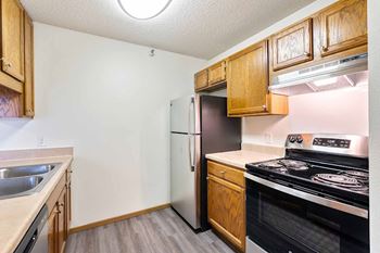 A kitchen with wooden cabinets and a black stove top oven.