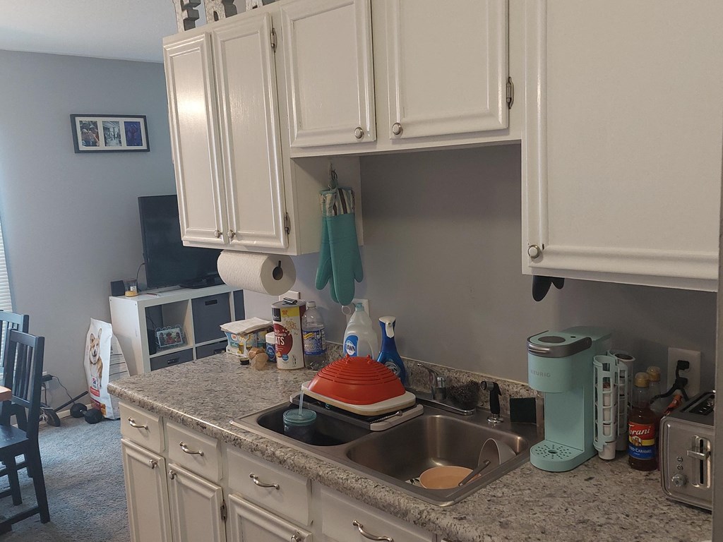 a kitchen with white cabinets and granite countertops