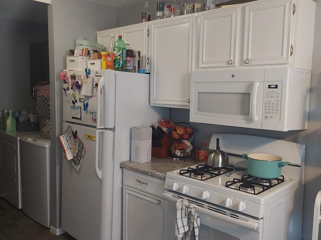 a kitchen with white appliances and white cabinets