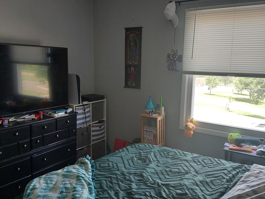 a bedroom with a tv and a dresser