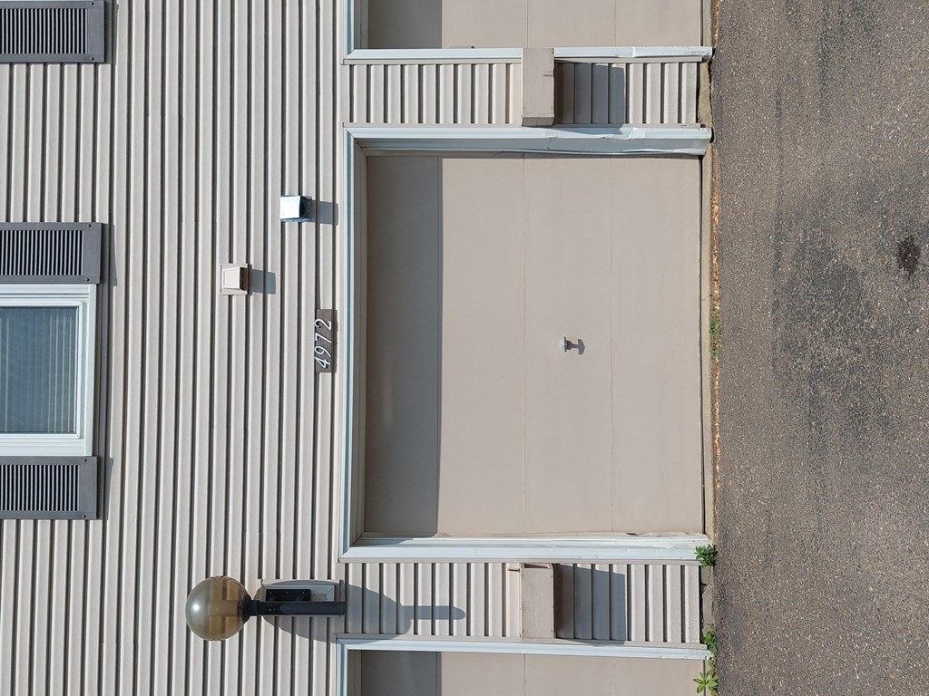 a view from above of a building with a white door and grey and white stripes