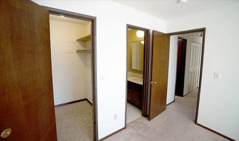 a bedroom and a bathroom with a closet and a mirror
