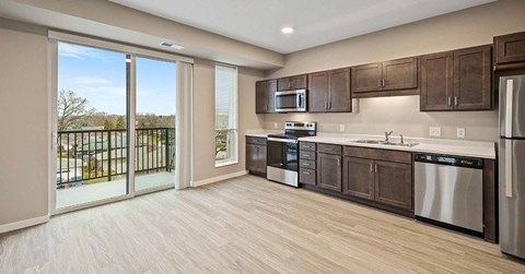 A modern kitchen with dark wood cabinets and stainless steel appliances.