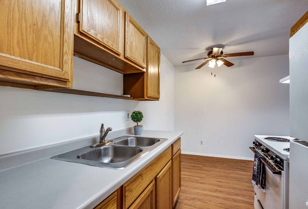 A kitchen with wooden cabinets and a stainless steel refrigerator.