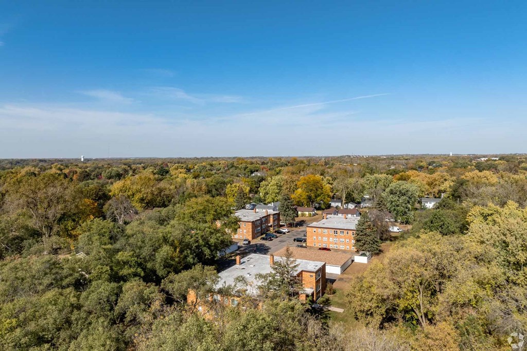 A bird's eye view of a large building surrounded by trees.