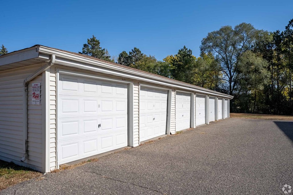 A row of white garage doors are closed and lined up in a row.