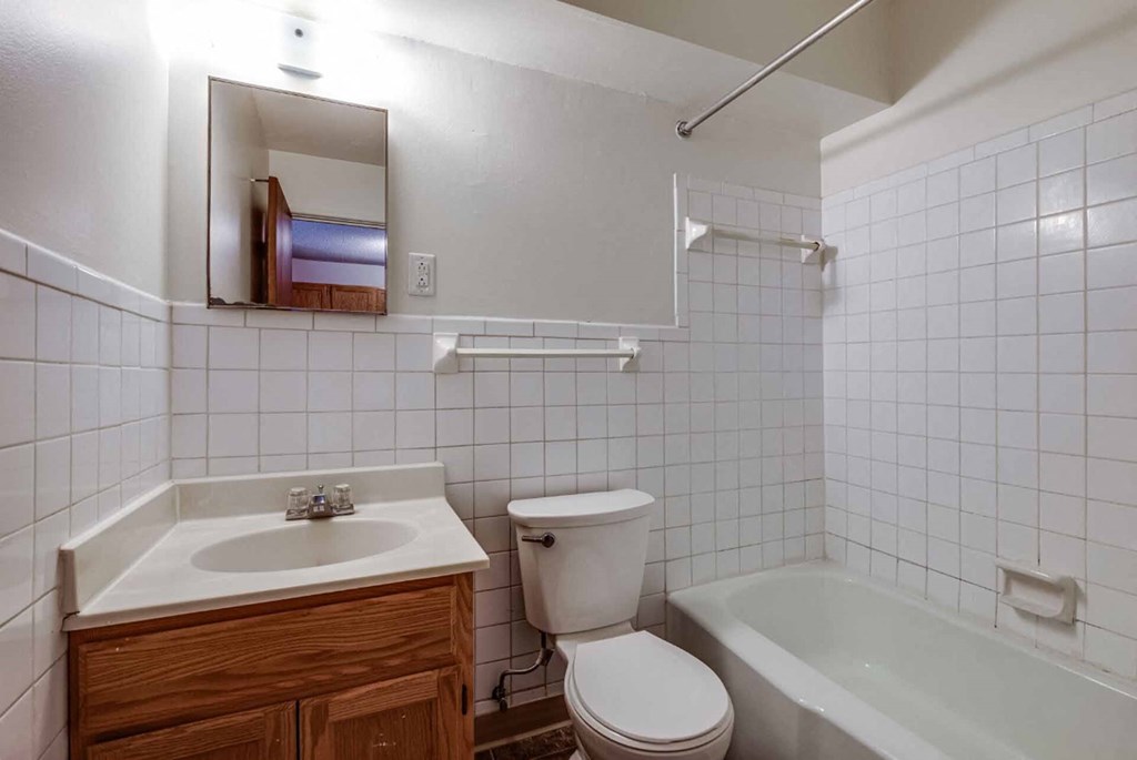 A white bathroom with a toilet, sink, and bathtub.
