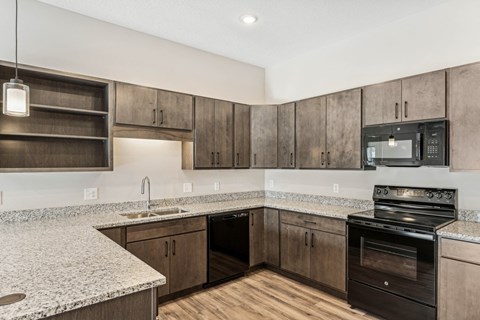 A kitchen with wooden cabinets and a granite countertop.