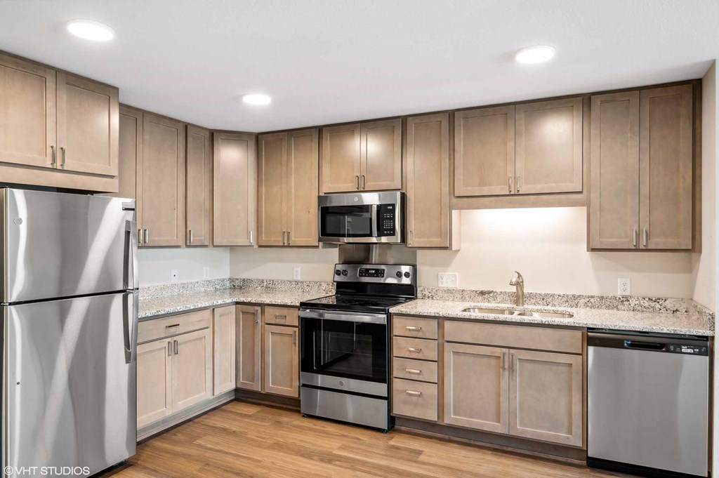 a kitchen with wooden cabinets and stainless steel appliances
