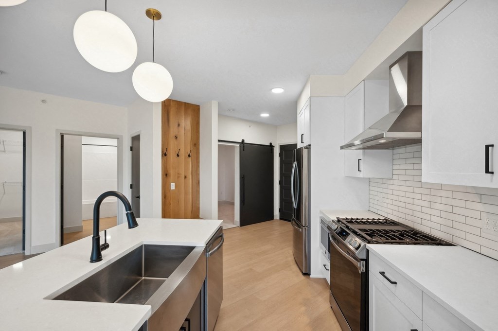 a renovated kitchen with white cabinets and a large sink