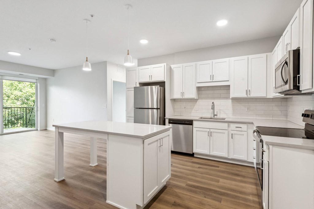 an open kitchen with white cabinets and stainless steel appliances