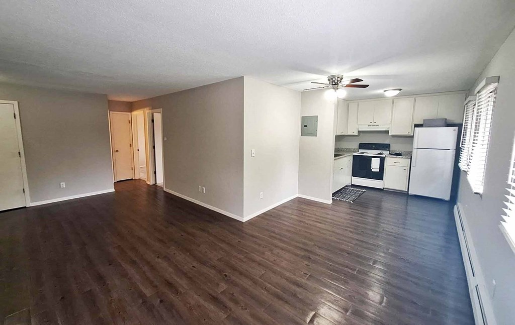 A kitchen with white cabinets and a refrigerator.