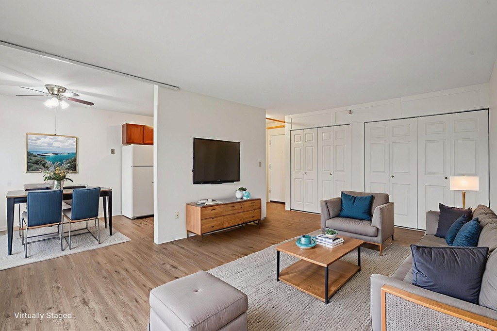 A living room with a grey couch, a wooden coffee table, and a painting on the wall.