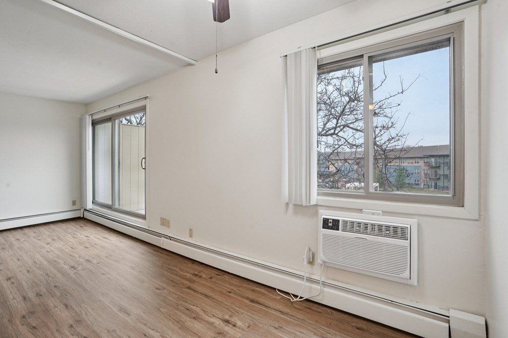 A room with a window and a white wall.