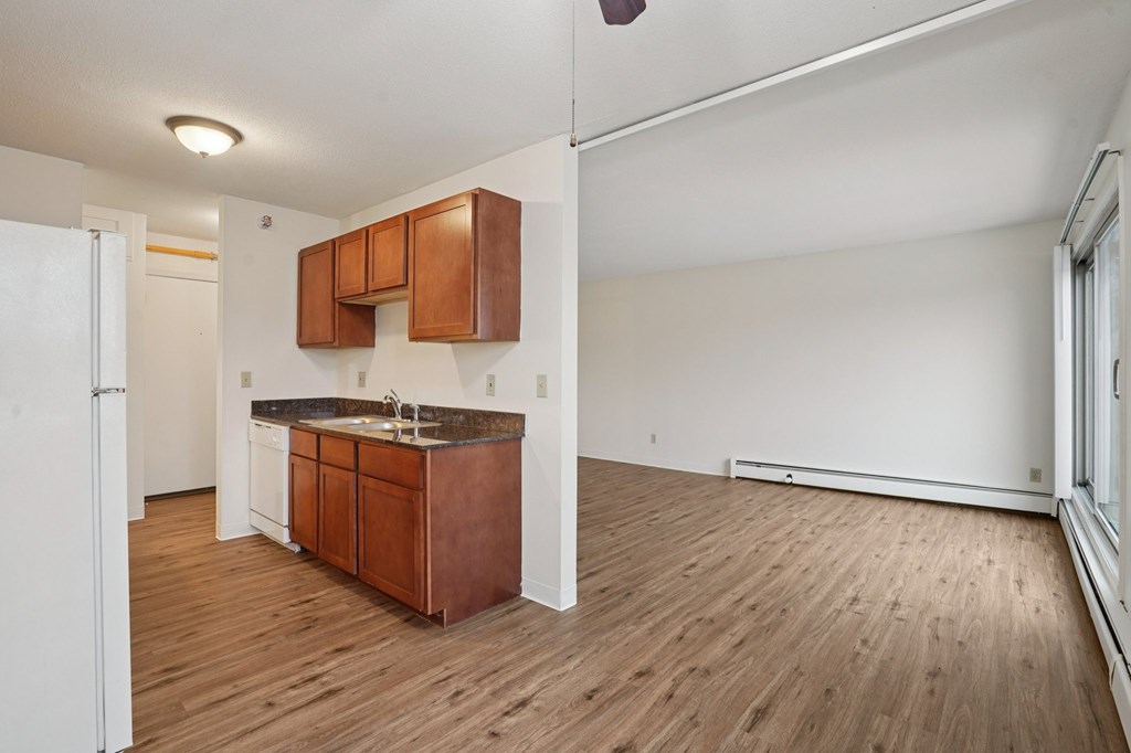 A kitchen with wooden floors and white walls.