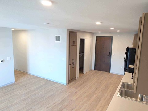 A kitchen area with a sink and a refrigerator.