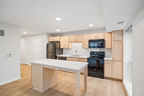 a large kitchen with wooden cabinets and a white counter top