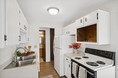 a kitchen with white cabinets and a stove and a sink