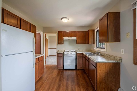 A kitchen with wooden cabinets and a white refrigerator.