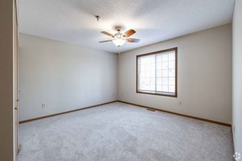 A room with a ceiling fan and a window.