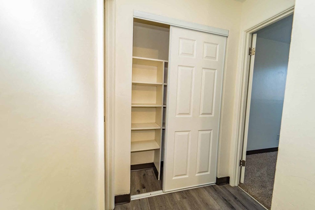 A white door is open to a room with shelves.
