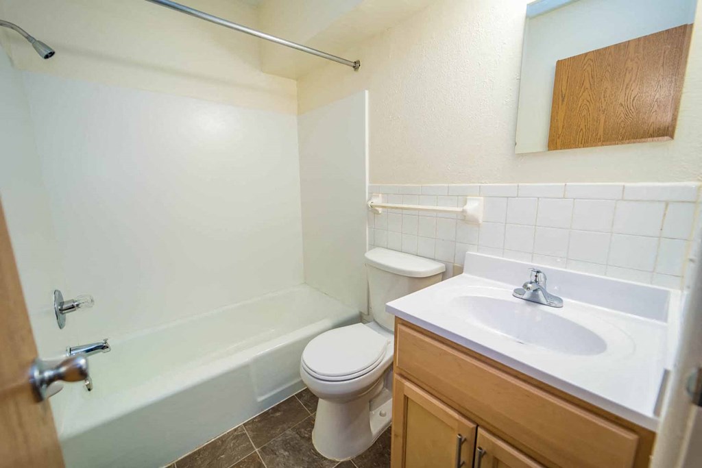 A white toilet sits next to a white sink in a bathroom.