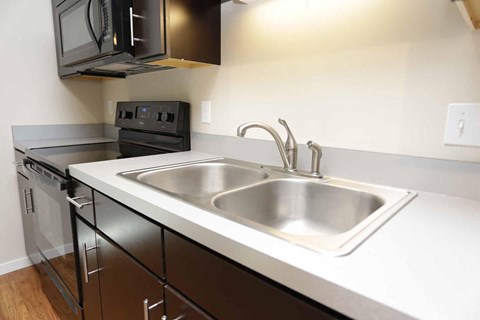 a kitchen with a sink and a stove and a microwave