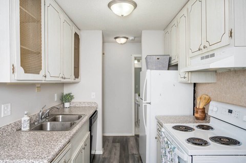 a kitchen with white appliances and granite counter tops