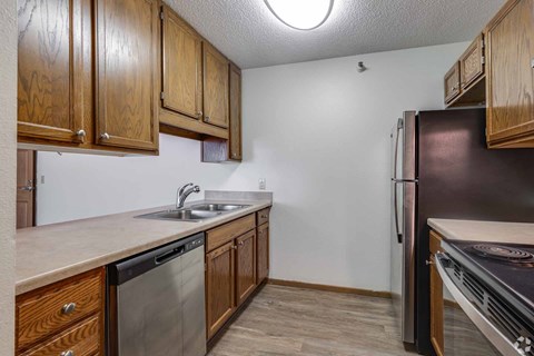 A kitchen with wooden cabinets and a black refrigerator.