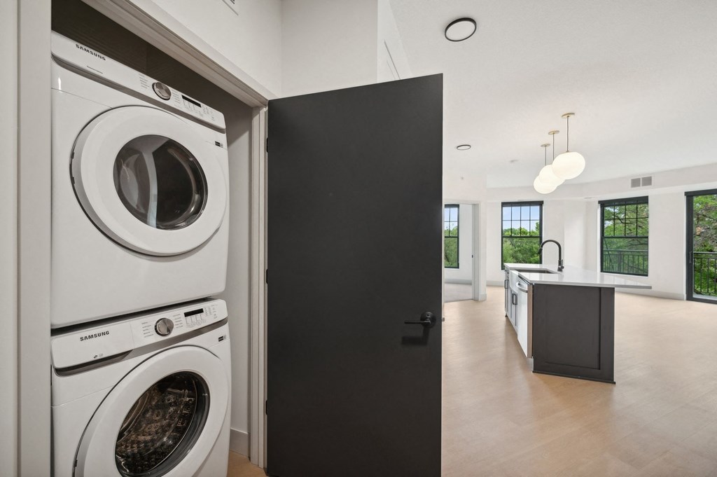a white washer and dryer in a room with a black door