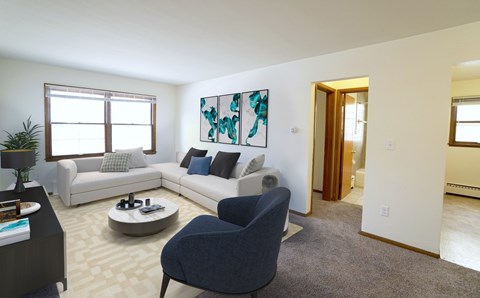 A living room with a grey armchair and a white sofa.