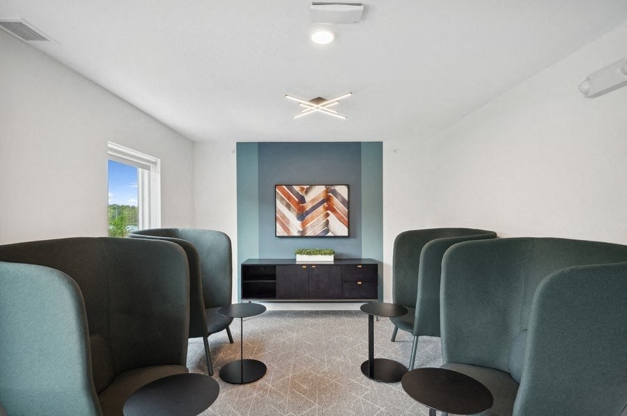 a meeting room with chairs and a table and a clock on the wall