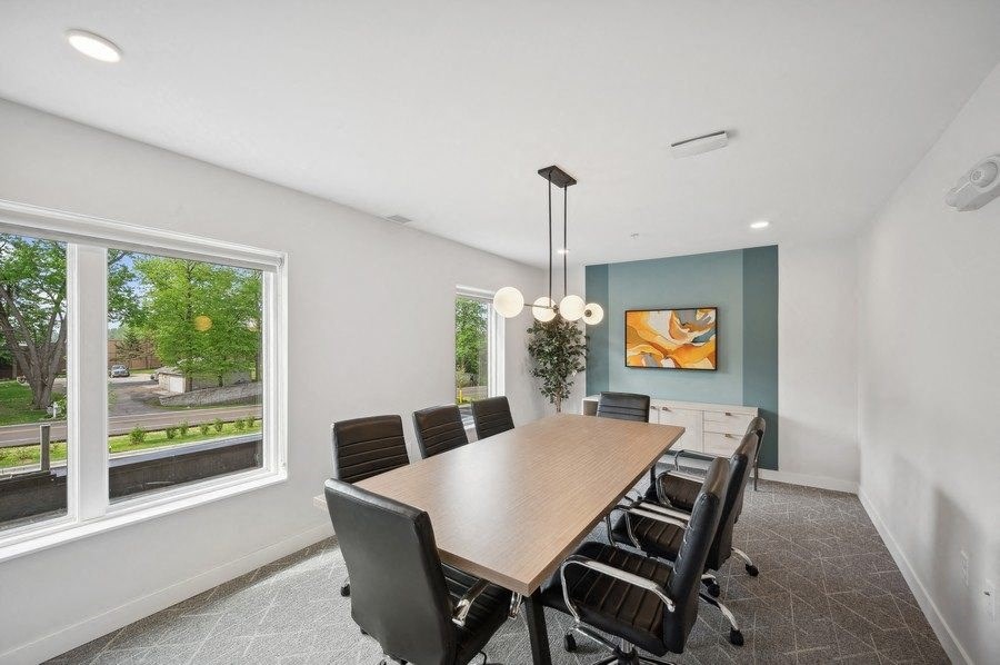 a conference room with a large window and a wooden table and chairs