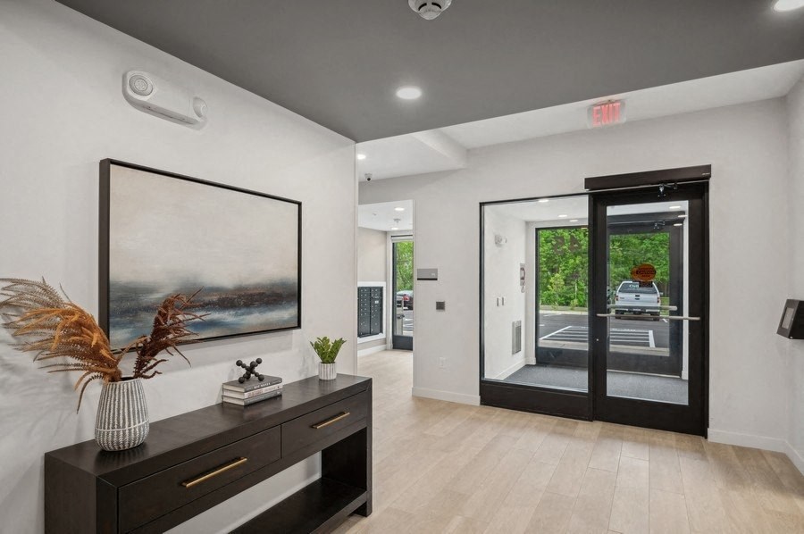 the living room has a large picture on the wall and a door to the street