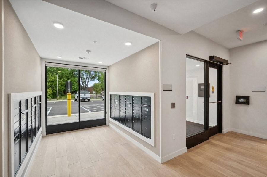 the lobby of a building with a glass door and a street view