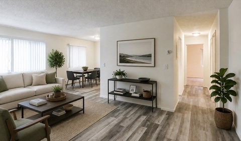 A living room with a white couch, a coffee table, and a painting on the wall.