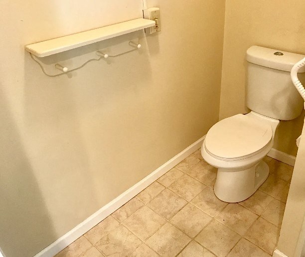 a white toilet sitting in a bathroom next to a toilet paper roll