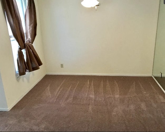 an empty room with a window and a curtain