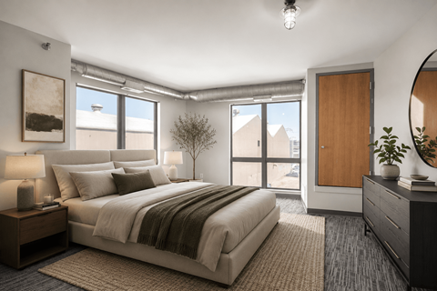 A well-lit bedroom with a large bed and a view of the outside.